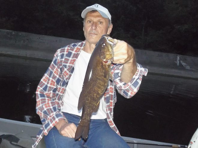 Kirby Romesburg of Cuyahoga Falls with a smallmouth bass he took in the Cuyahoga River.