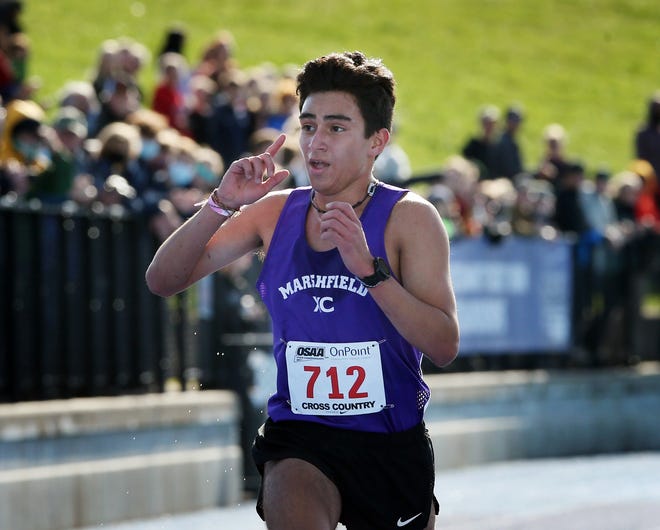 Marshfield's Alexander Garcia-Silver acknowledges the crowd as he wins the Class 4A boys cross country championship meet at Lane Community College on Saturday.