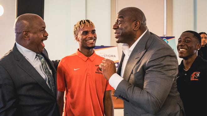 Earvin Magic Johnson shares a story with FAMU men's basketball head coach Robert McCullum (far left), MJ Randolph (orange shirt) and Kamron Reaves.