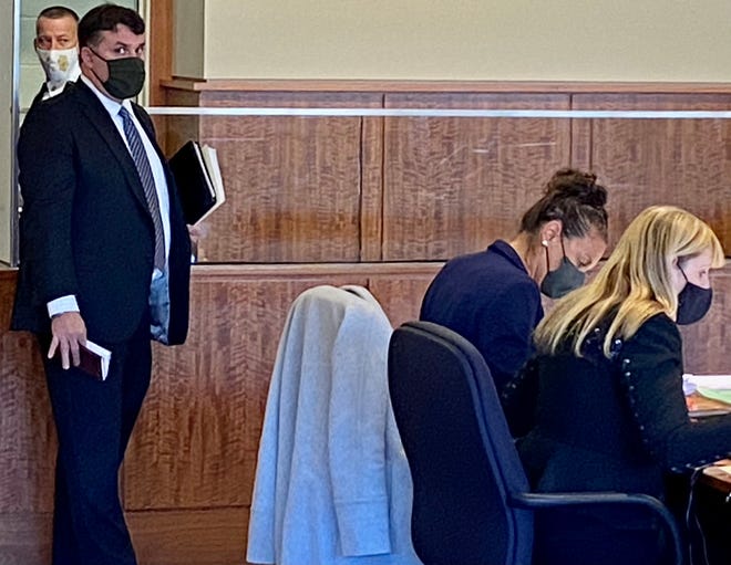 Murder suspect Nelson Coelho is obscured by his defense attorney Dana Sargent during arraignment in Fall River District Court.