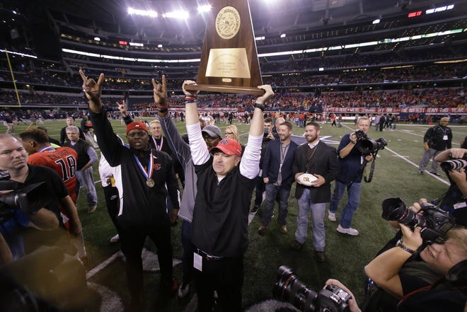 Joey McGuire, holding his Cedar Hill teams' third state-championship trophy, will be inducted into the Texas High School Football Hall of Fame in May as part of a nine-member class. McGuire was recently hired as head coach at Texas Tech.