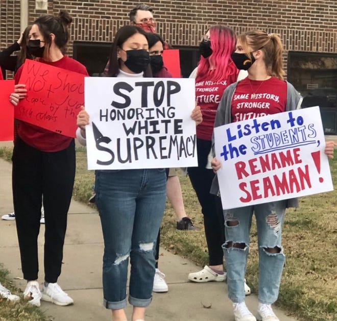 Seaman High School students who supported changing the name of their school held signs during a protest prior to Monday's Seaman USD 345 school board meeting.