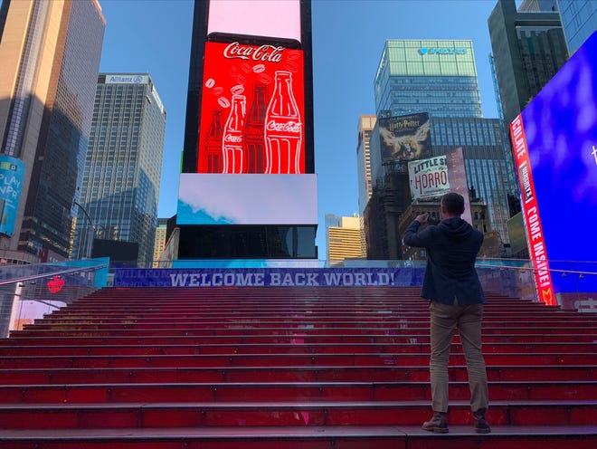 The Red Steps at Time Square on Nov. 8, 2021, displaying a "Welcome Back World!" sign.