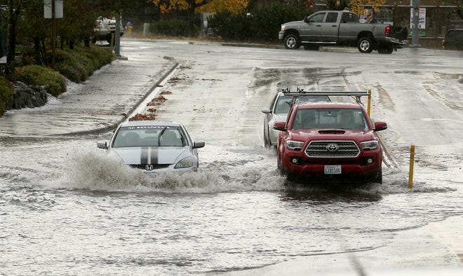 Motorists navigate through the deep water on Kitsap Mall Blvd. after the storm moves through Silverdale on Tuesday Nov. 9, 2021.