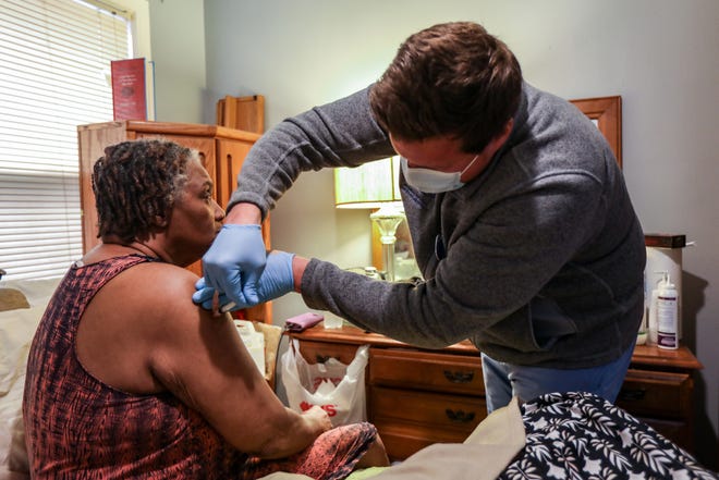 Registered nurse Michael Garcia, 37, of Wyandotte, will administer a Pfizer COVID-19 vaccine booster to Diane Elaine May-Bey, 70, at her home in Detroit on Tuesday, November 9, 2021. of Henry Ford Health System's Global Health Initiative and provides the service to patients in need.