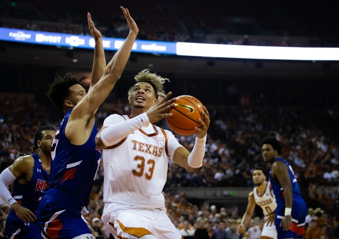 Longhorns forward Tre Mitchell (33) pushes past Huskies forward Zion Tordoff (15) to get to the basket during the first half of the Texas game against the Houston Baptist University on Nov. 9, 2021 in Austin. 
