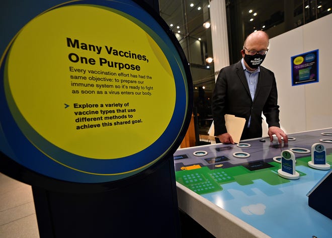 Congressman James McGovern tries out the Ecotarium's new vaccine exhibit.