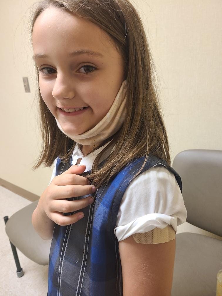 Elizabeth Rigney, 8, get a dose of the Pfizer vaccine.