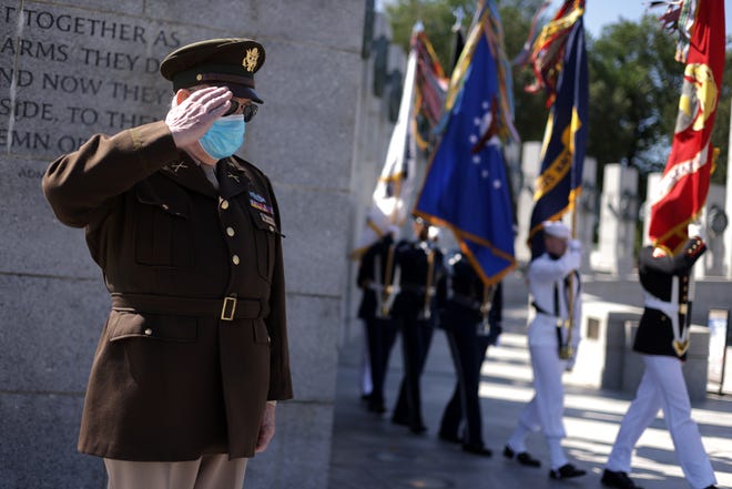 U.S. Army veteran C. Patrick McCourt wears an Army dress uniform from the World War II era as he salutes during presentation of colors at a V-J Day event at the National World War II Memorial September 2, 2021 in Washington.