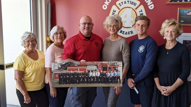 Okaloosa Island Fire Department Chief Michael Ray Strawn (left) and Engineer Corey Crawford pose with Okaloosa Island Garden Club members (left to right) President Kathy Foster, Treasurer Paula Hudson, Vice President Ricki Roberts and Secretary Susan Wall. The club has created a 2022 calendar to help purchase life-saving equipment for the department.