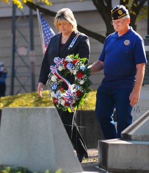 Dee Grimm and David Leasure lay a wreath in memory of fallen military members during an event at Alliance City Cemetery. Gannett File Photo