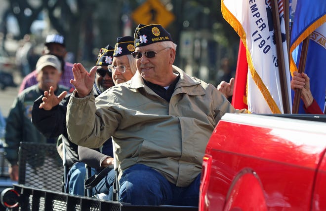 A group of veterans wave to the crowd as they take part in the annual Veterans Day Parade held Thursday morning, Nov. 11, 2021, in Uptown Shelby.
