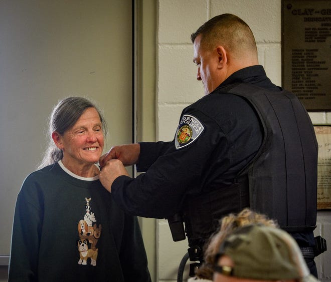 Genoa Police Chief and Air Force veteran Matt Herrig pins Navy veteran Carolyn Lasseter, who served from 1971 to 1998.