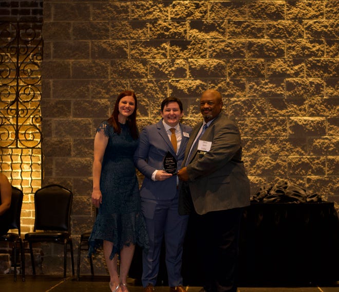 Emcee Becca James of Star 102.1 and YPK president-elect Rikki Frost present the Rev. Chris Battle and BattleField Farm & Gardens with the “Serve” Impact Award at the 9th Annual Young Professionals of Knoxville awards. Nov. 5, 2021
