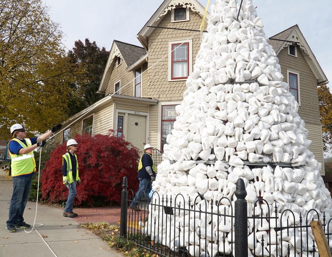          Dan Diachenko of Euko Design helps to put together Preservation Dental's toothy Christmas Tree on Nov. 11, 2021. The tree, at the corner of Griswold and W. Main, will be lit up through the holidays.