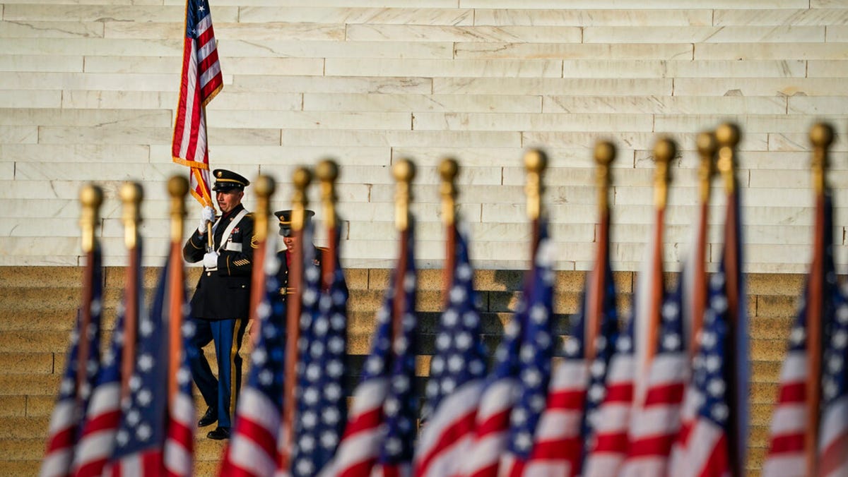 Honor guards carry the U.S. flag from the steps of the Lincoln Memorial before a Veterans Day event in Washington to honor those who have served in the armed forces.