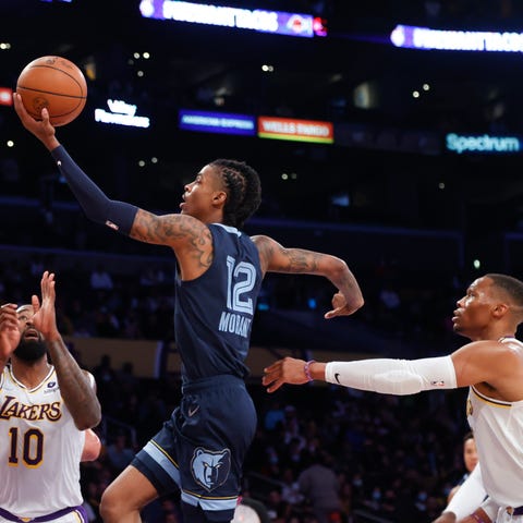 Grizzlies guard Ja Morant (12) drives to basket be