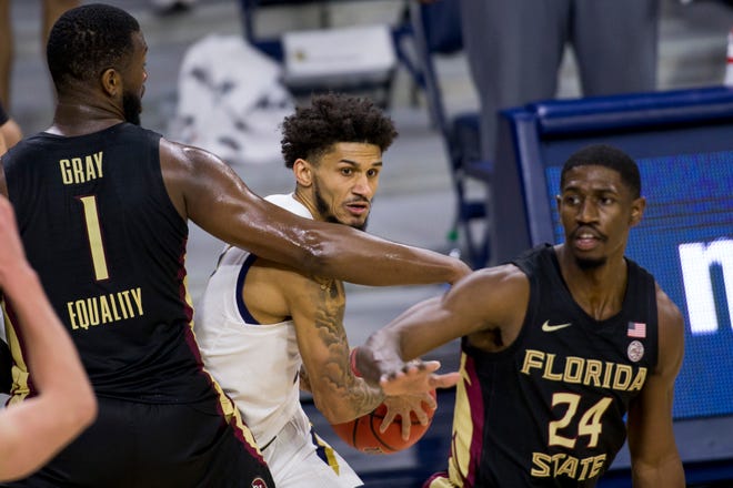 Notre DameÕs Prentiss Hubb, center, gets pressure from Florida State's RaiQuan Gray (1) and Sardaar Calhoun (24) during the second half of an NCAA college basketball game Saturday, March 6, 2021, in South Bend, Ind. Notre Dame won 83-73. (AP Photo/Robert Franklin)