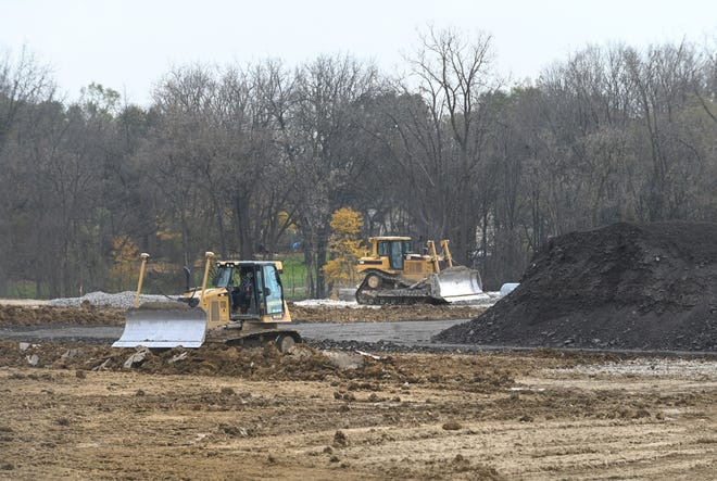 Peralatan pemindah tanah meratakan tanah untuk pabrik aspal Ajax Paving masa depan yang terletak di sepanjang Energy Drive di luar Carpenter Road di tepi batas kota Flint.