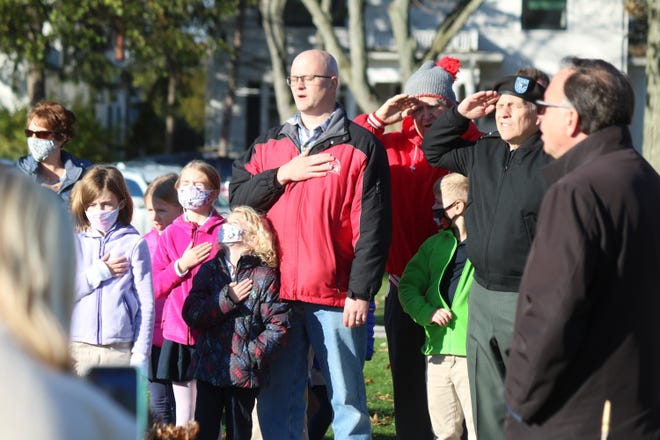 Local veterans join Immaculate Conception School students as they sing the national anthem together as part of their Veterans Day ceremony held Friday at the memorial on the Ottawa County Courthouse lawn.