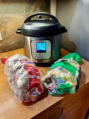 Stock being made from frozen vegetable scraps and leftover chicken bones in an Instant Pot.