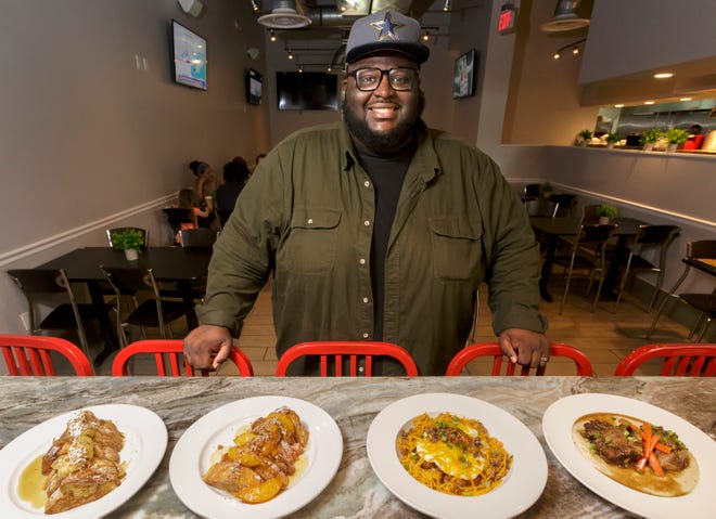 John LeJeune, owner of Big John's Eatery in suburban West Palm Beach, poses with some favorite "brunch all day" dishes. He and his wife Sasha turned a former pizzeria into a thriving soul food diner.