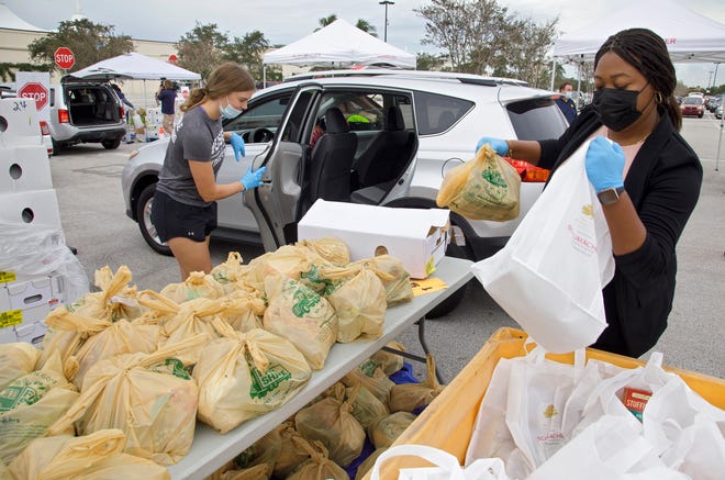 Volunteers load Thanksgiving dinners into cars at Palm Beach Outlets in West Palm Beach Friday, November 12, 2021. A Thanksgiving meal (turkey and sides), along with produce, dairy, and non-perishable food were distributed to 500 families. The volunteers ran out of turkeys less than an hour after the event began; one worker said, "This is one of the biggest turnouts we've had in a while." The Tree of Life Resource Center, a sponsor of the event, offers food assistance and other resources to those in need. For more information about food or services, contact them at 561-656-5601, or at TreeofLifefi.org. Additional sponsors were Schumacher Auto Group and Farm Share's The Big Red Truck.