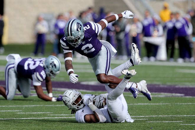 West Virginia wide receiver Winston Wright Jr. (1) is tackled by Kansas State Wildcats defensive back Russ Yeast on Saturday at Bill Snyder Family Football Stadium.