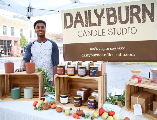 Reggie Nelson, owner of Daily Burn Candle Studio, poses with his candles and other creations in his two at the Newberry Farmers Market on November 13th in Newberry. Nelson makes his candles from 100% vegan soy wax with a wooden wick. The Daily Burn also sells warmer wax, candle ware, and Jesmonite candles.