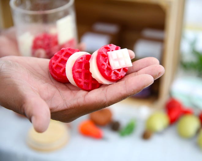 Reggie Nelson, owner of Daily Burn Candle Studio, is showing some of the warmer waxes at his booth in Newberry Farmers Market.