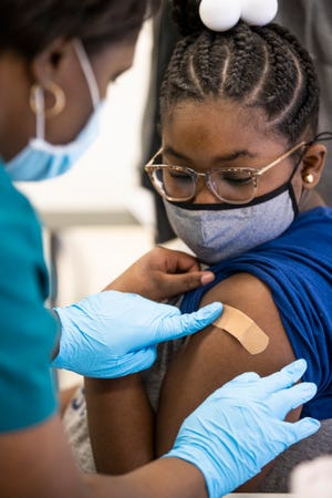 Laryah Wakefield, 10, looks as she receives a COVID-19 vaccine at Carter Traditional Elementary School in Louisville during a vaccine drive.
