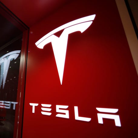 This Feb. 9, 2019, file photo shows a sign bearing the company logo outside a Tesla store in Cherry Creek Mall in Denver.
