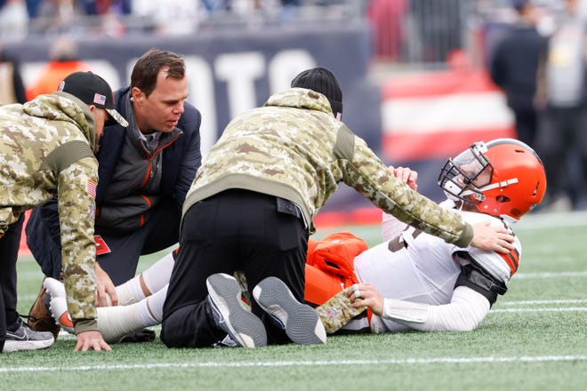 Cleveland Browns quarterback Baker Mayfield (6) is tended by medical personal after taking a hit during the second half of an NFL football game against the New England Patriots, Sunday, Nov. 14, 2021, in Foxborough, Mass. (AP Photo/Greg M. Cooper)