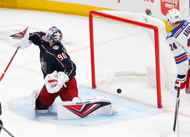 Blue Jackets goalie Elvis Merzlikins misses the puck in a 5-3 loss to the Rangers on Saturday.