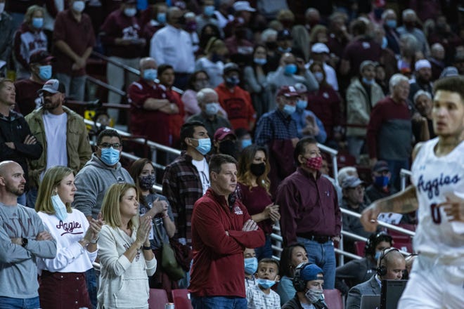 Some fans — including Mayor Ken Miyagishima, bottom right in red and white mask — wear masks as the New Mexico State Aggies face off against the UTEP Miners at the Pan American Center in Las Cruces on Saturday, Nov. 13, 2021.
