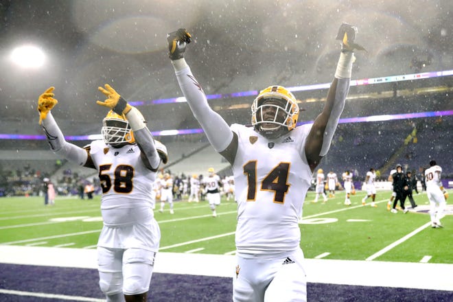 Joe Moore #58 dan Stanley Lambert #14 dari Arizona State Sun Devils merayakan setelah mengalahkan Washington Huskies dengan skor 35-30 di Husky Stadium pada 13 November 2021 di Seattle, Washington.