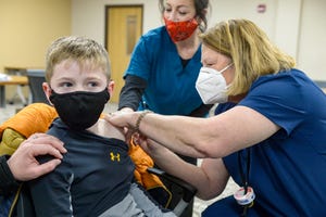 Kashton Scott-Kidrick, age 7, receives the Covid-19 vaccine from nurse Leigh Spencer during the City-County Health Department's Covid and flu vaccine clinic on Monday at Great Falls College-MSU.