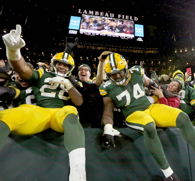 Green Bay Packers running back A.J. Dillon (28) celebrates scoring his first of two rushing touchdowns with a Lambeau leap with Green Bay Packers offensive tackle Elgton Jenkins (74) during the second half of the 17-0 win at Lambeau Field in Green Bay on Sunday, Nov. 14, 2021.   Photo by Mike De Sisti / Milwaukee Journal Sentinel via USA TODAY NETWORK