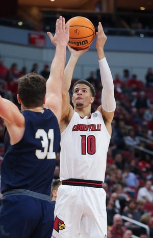U of L's Samuell Williamson (10) shoots against Navy's Daniel Deaver (31) during their game at the Yum Center in Louisville, Ky. on Nov. 15, 2021.
