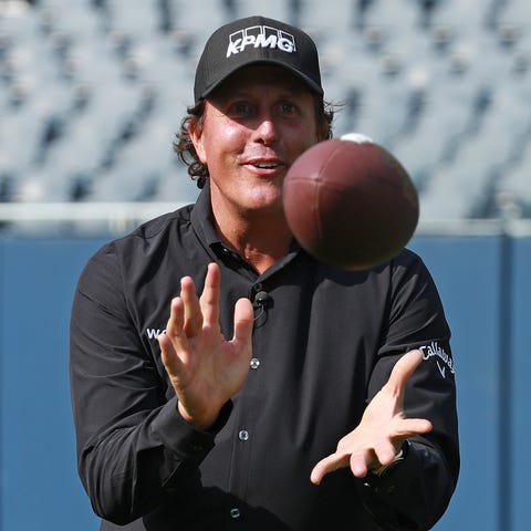 Phil Mickelson plays with a football at Soldier Fi