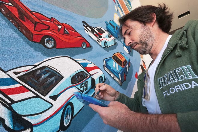 Erwin Dazelle working on a racing mural at the Dayona Hotel at One Daytona.