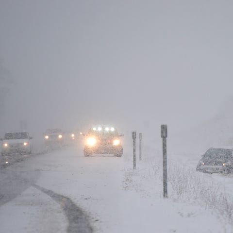 A police car moves traffic to the right lane as a 