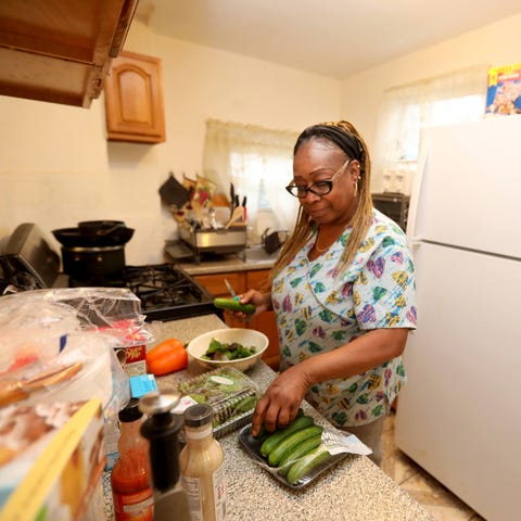 Angela Washington, 57, prepares a salad for dinner
