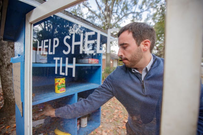 Kevin Forsthoefel restocks a Help Shelf TLH located in Frenchtown Thursday, Nov. 18, 2021. The shelf provides nonperishable food items for those who need them.