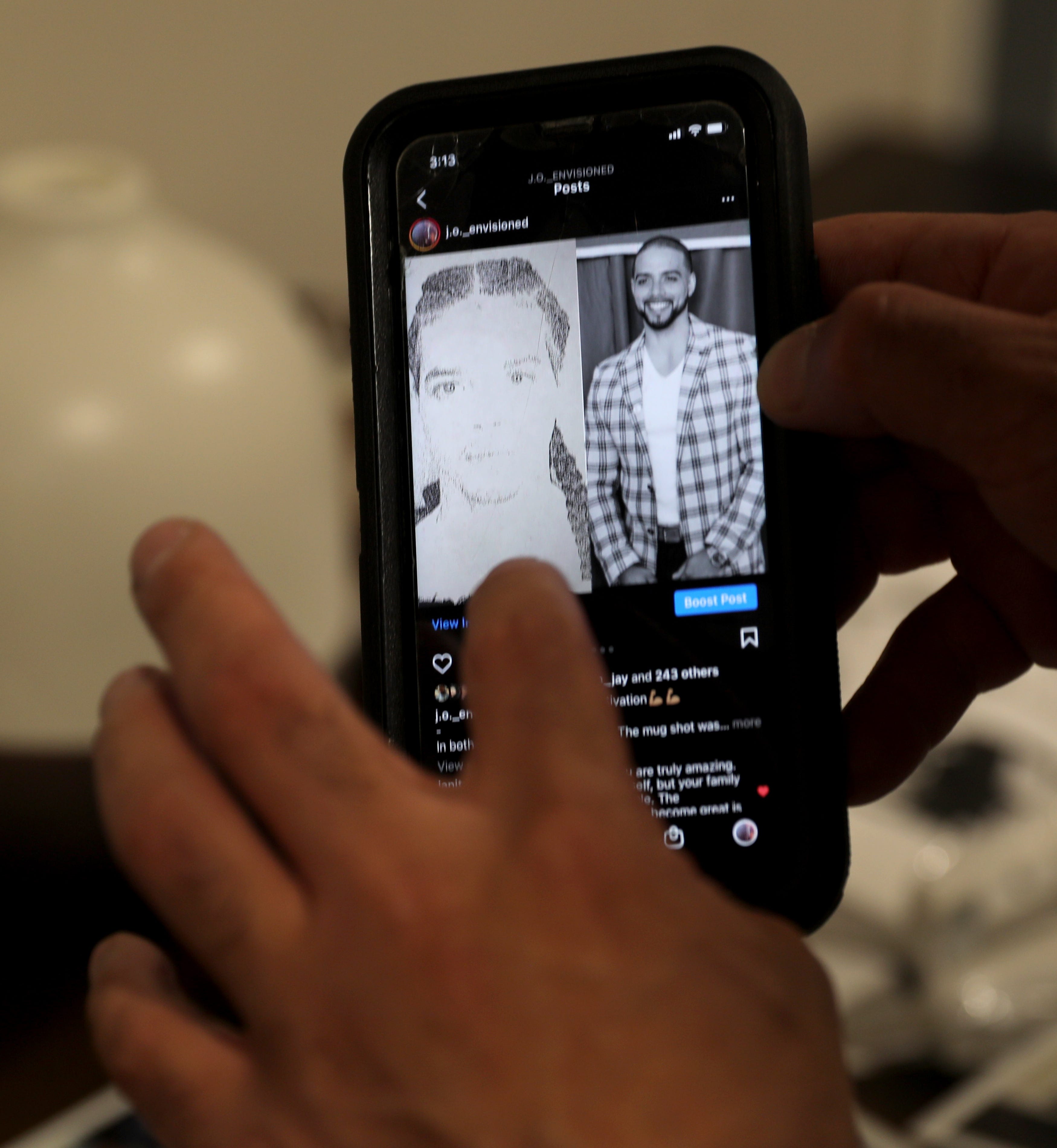 Jonathan Alvarez scrolls through some old photos on his phone, Nov. 18, 2021. Alvarez spent his last few teenage years and all of his 20s incarcerated. After his release, he co-founded 914United with John Cabrera, which focuses on education and mentorship in underserved communities.