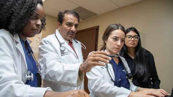 A health care team at a Miami clinic confers via v