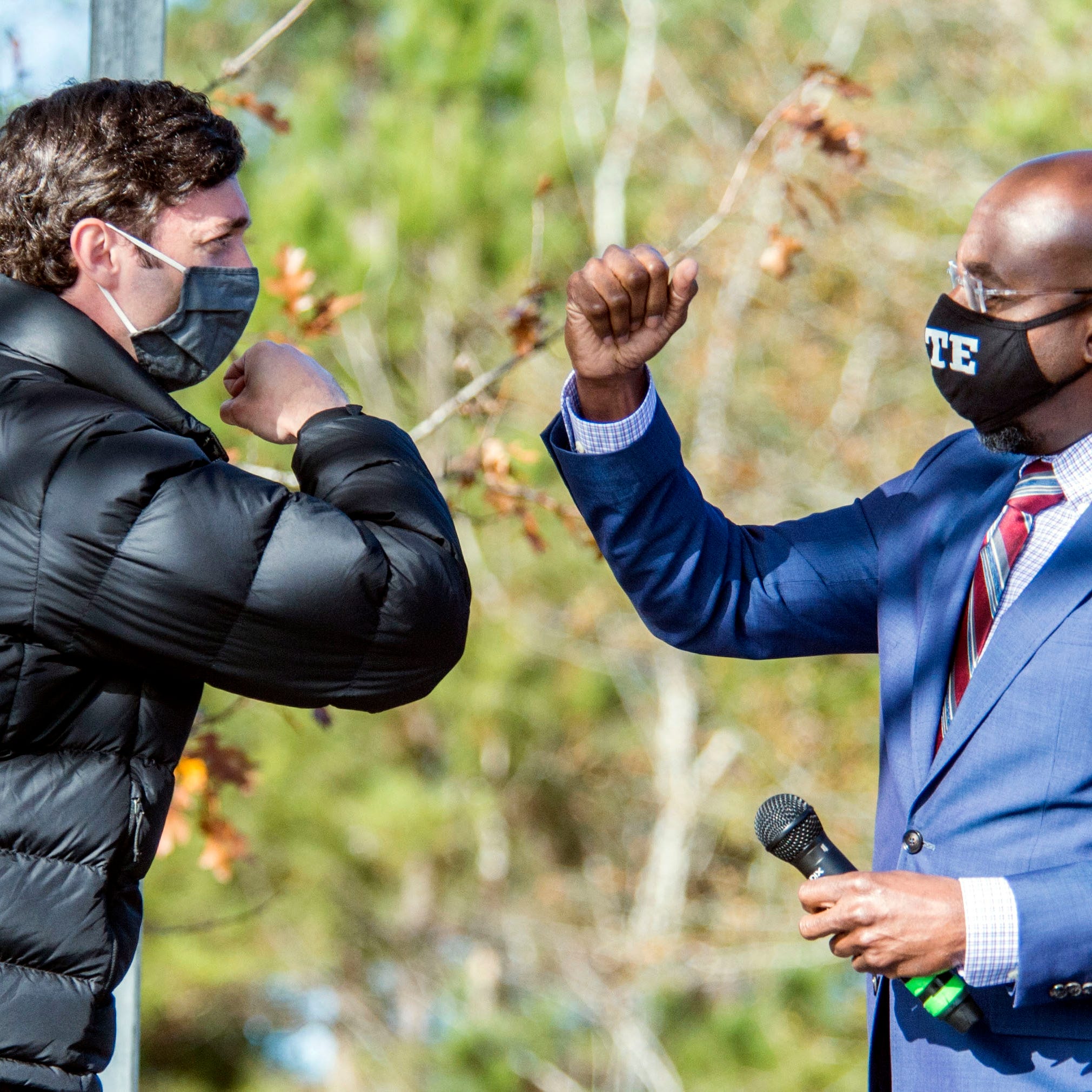 January 4, 2021:  Jon Ossoff, left, and Raphael Warnock exchange elbow bumps during a campaign rally in Augusta, Ga. Democrats Jon Ossoff and Rafael Warnock are challenging incumbent Republican Senators David Perdue and Kelly Loeffler in a runoff election.