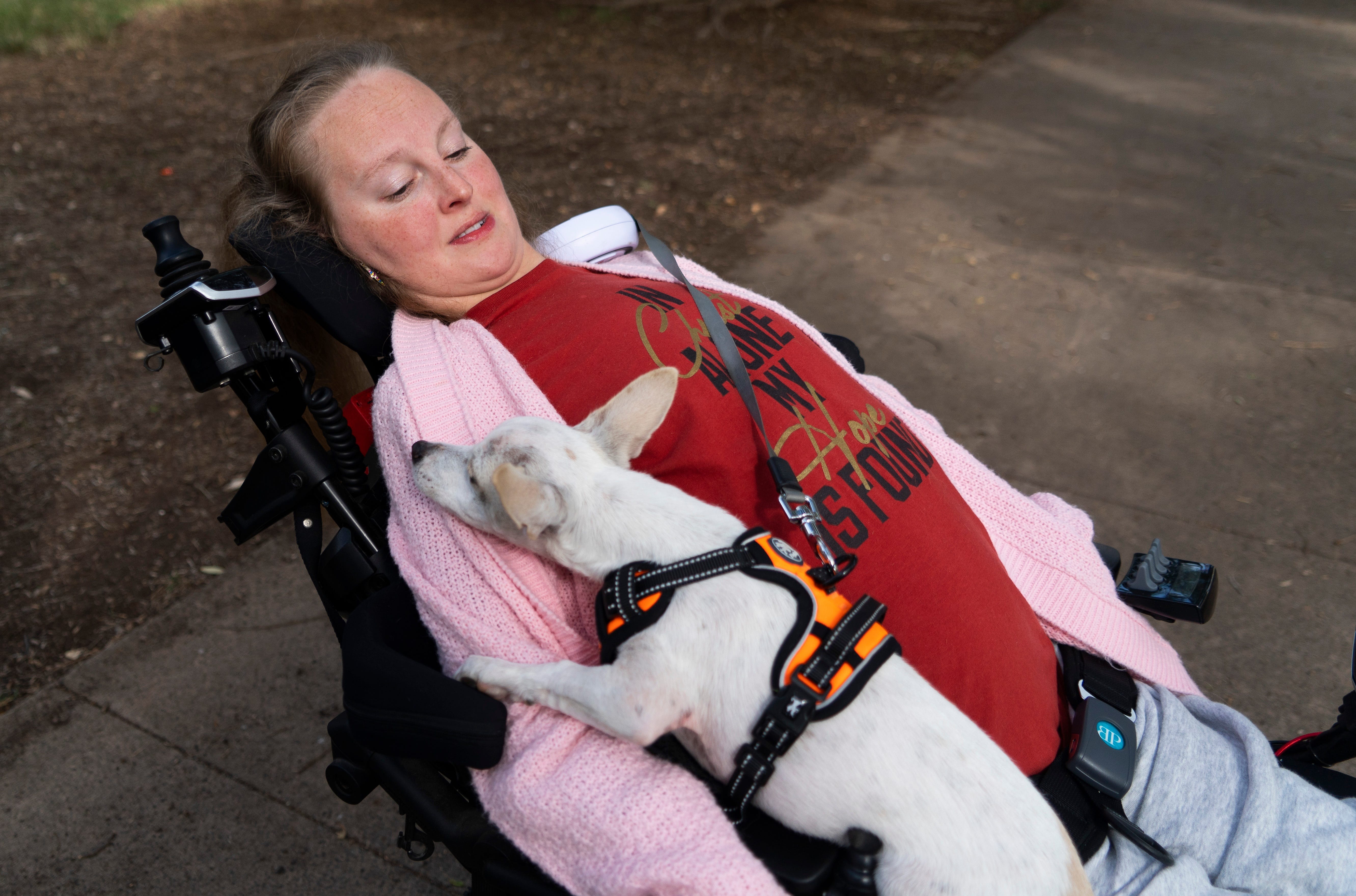 Laura Keenan with her companion dog Beanie Baby at Oak Grove Park in San Diego, Calif. On Nov. 18, 2021. Keenan, 27, has a genetic mutation that was officially identified by the NIH this year.
