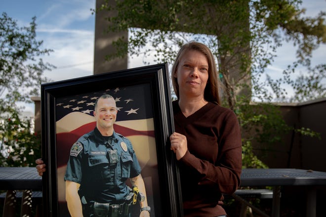 Melissa Traylor holds a photo of her husband, Austin police officer Andy Traylor, who was killed in a crash with an 18-wheeler while on duty. In 2021, Austin police reported 12 deaths caused by 18-wheeler crashes, an increase from one recorded in 2020.