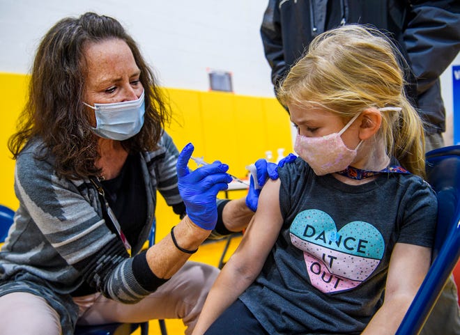 Hannah Knight gets her COVID-19 vaccine shot Nov. 18, 2021, from registered nurse Kim Cramer at the Super Shot COVID-19 Vaccine Clinic at Edgewood Primary School.